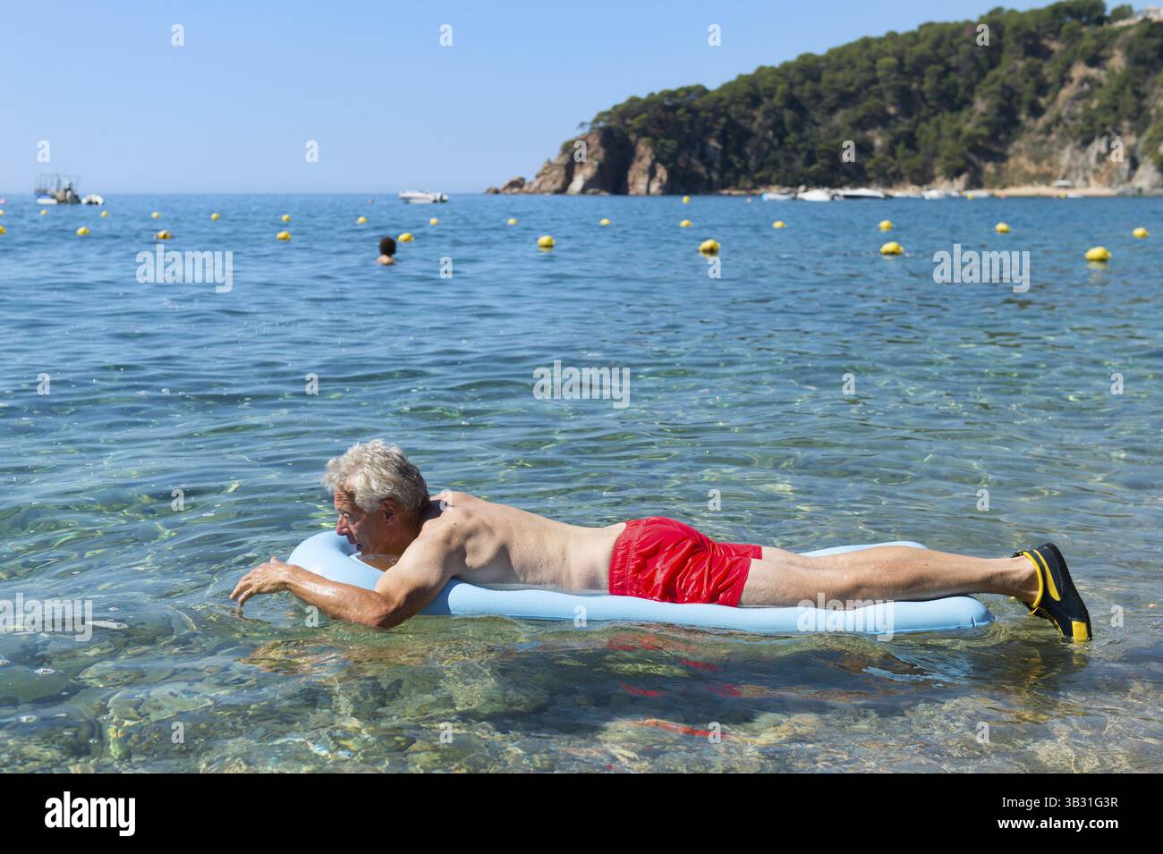 Libre de jouer avec lit gonflable flottant dans la mer Banque D'Images