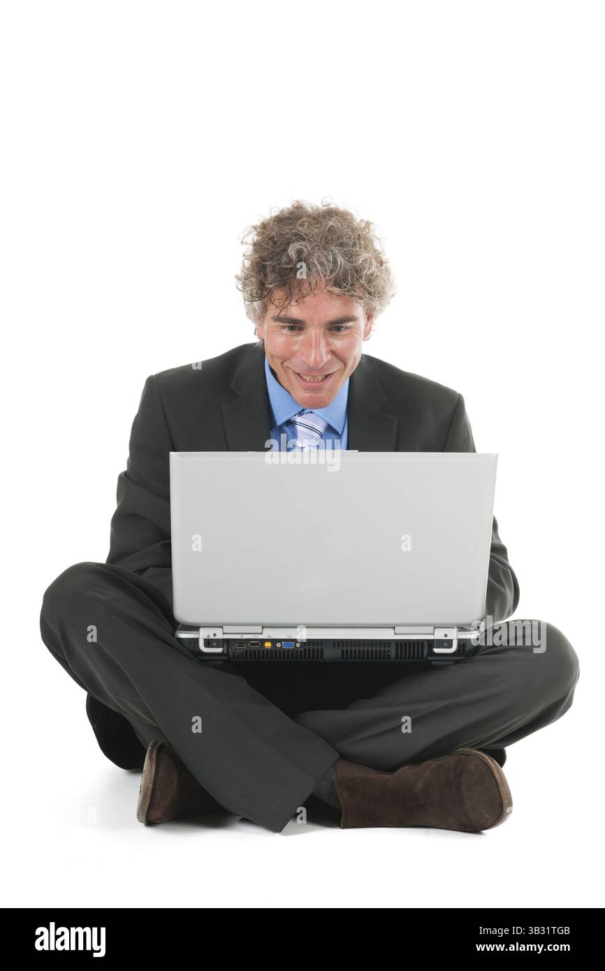 L'homme assis à l'étage tout en travaillant avec un ordinateur portable Banque D'Images