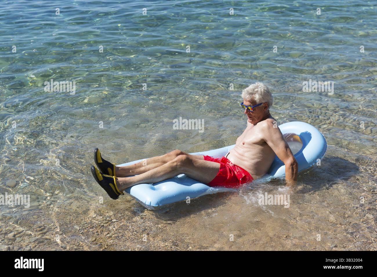 Libre de jouer avec lit gonflable flottant dans la mer Banque D'Images