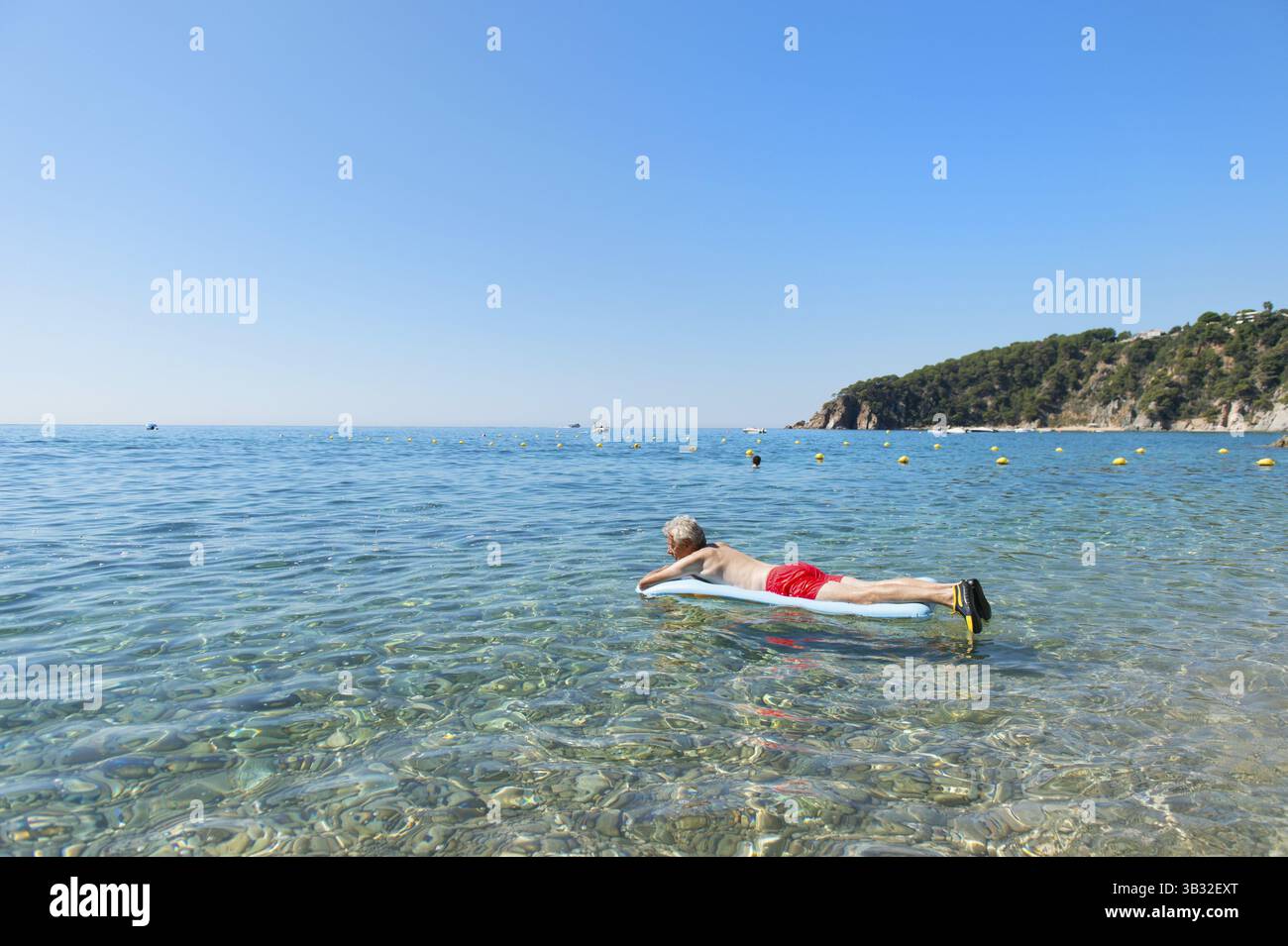 Libre de jouer avec lit gonflable flottant dans la mer Banque D'Images