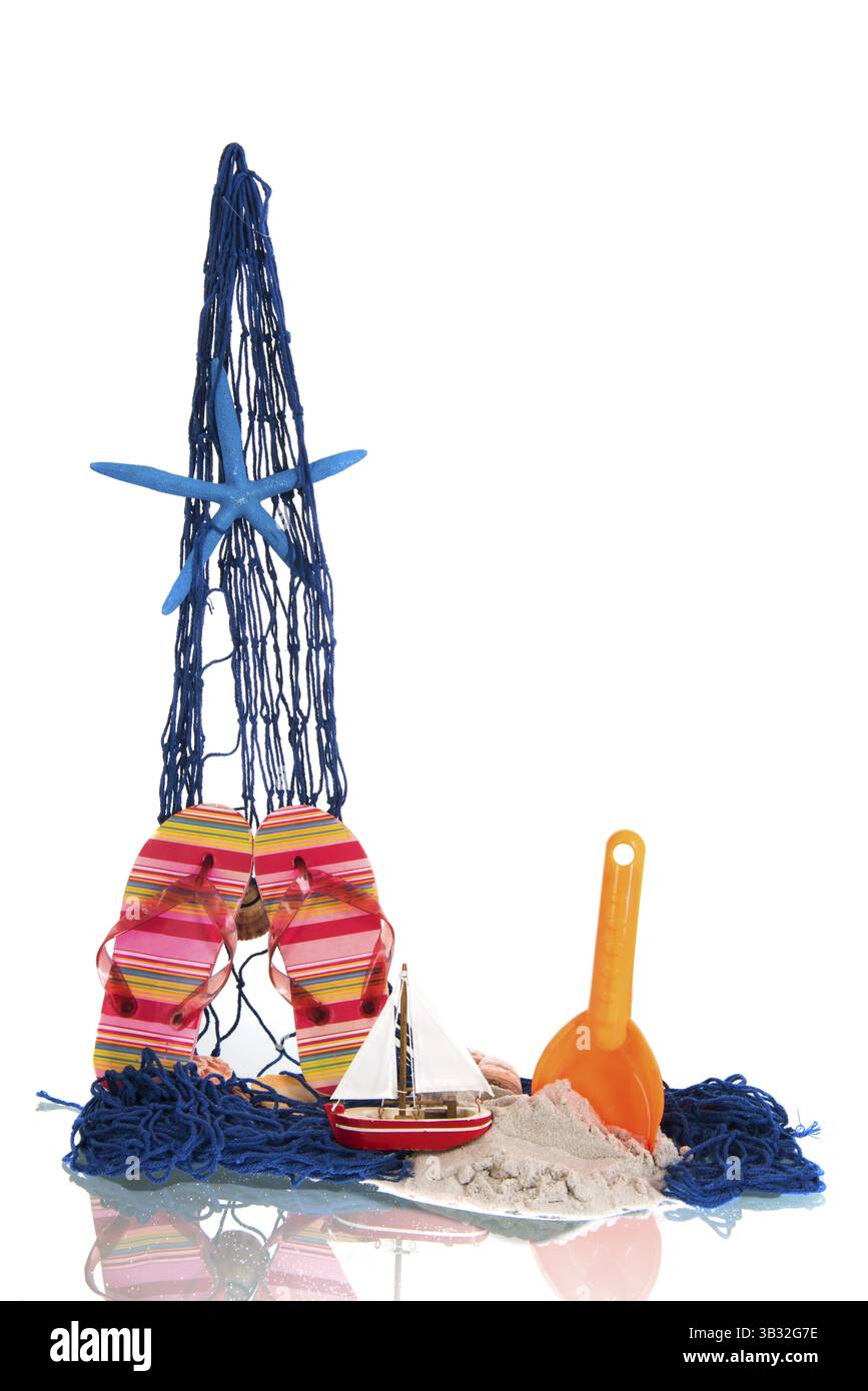 Filet de pêche avec jouets et poissons étoiles à la plage Banque D'Images