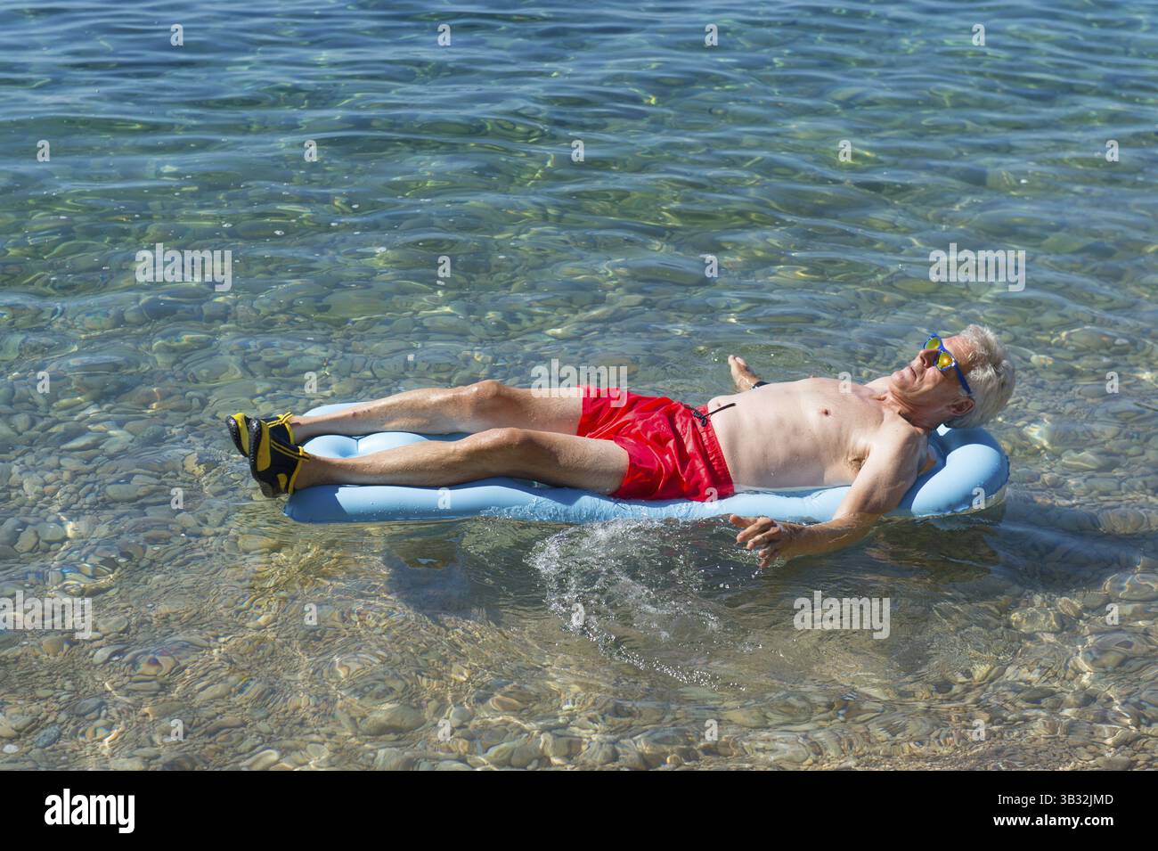 Libre de jouer avec lit gonflable flottant dans la mer Banque D'Images