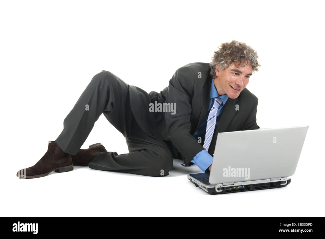 Pose de l'homme à l'étage tout en travaillant avec un ordinateur portable Banque D'Images