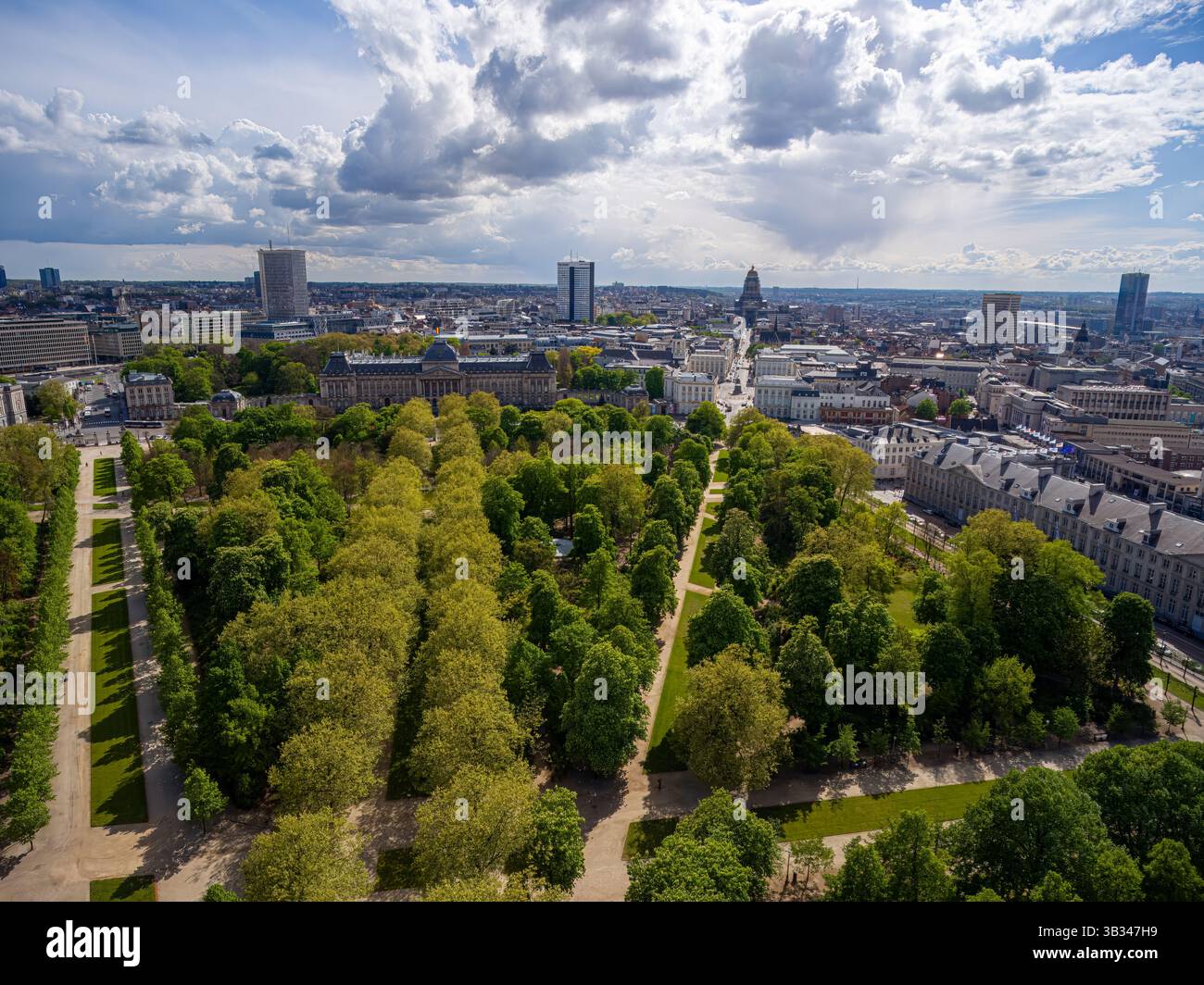 Bruxelles vu d'en haut : le vert urbain rencontre l'architecture historique. Oasis urbaine de Brussels Park contraste avec l'horizon de la ville sous des nuages spectaculaires. Banque D'Images