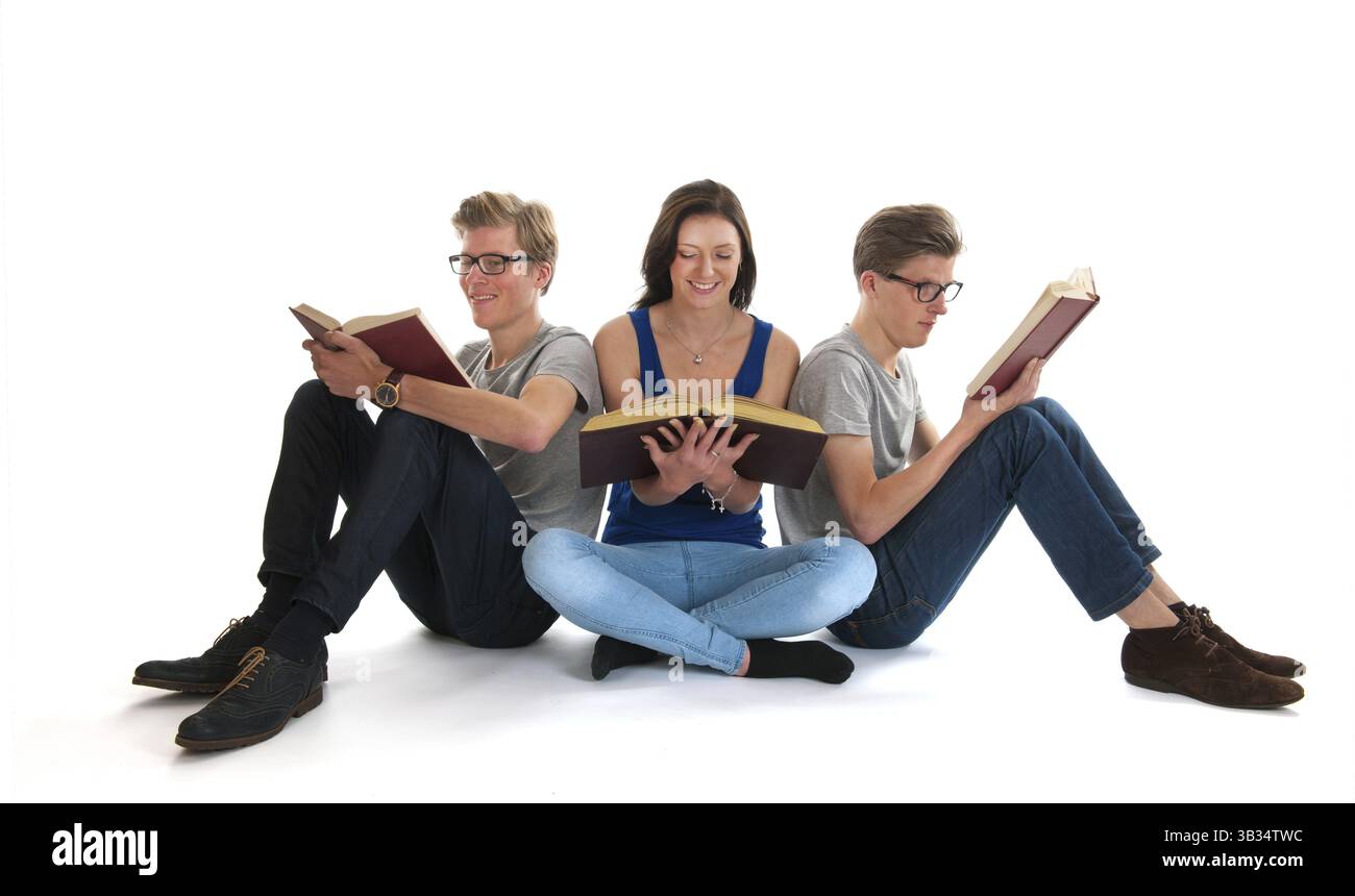 De la même manière avec des jumeaux mâles adultes girl reading books in studio Banque D'Images