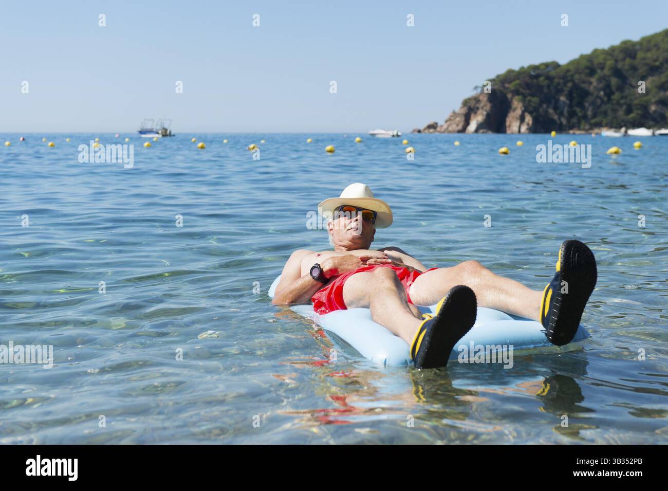 Libre de jouer avec lit gonflable flottant dans la mer Banque D'Images