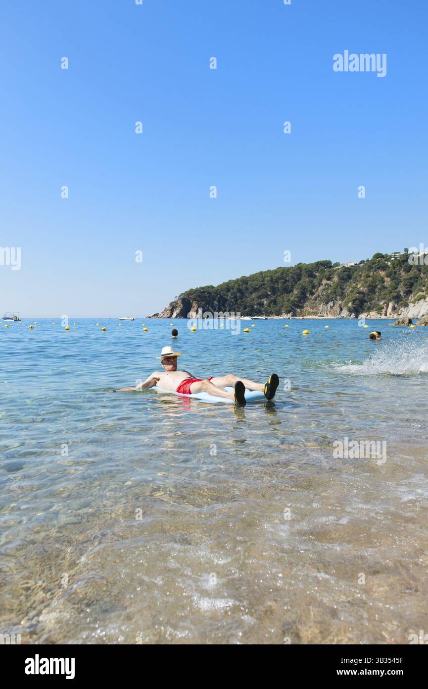 Libre de jouer avec lit gonflable flottant dans la mer Banque D'Images
