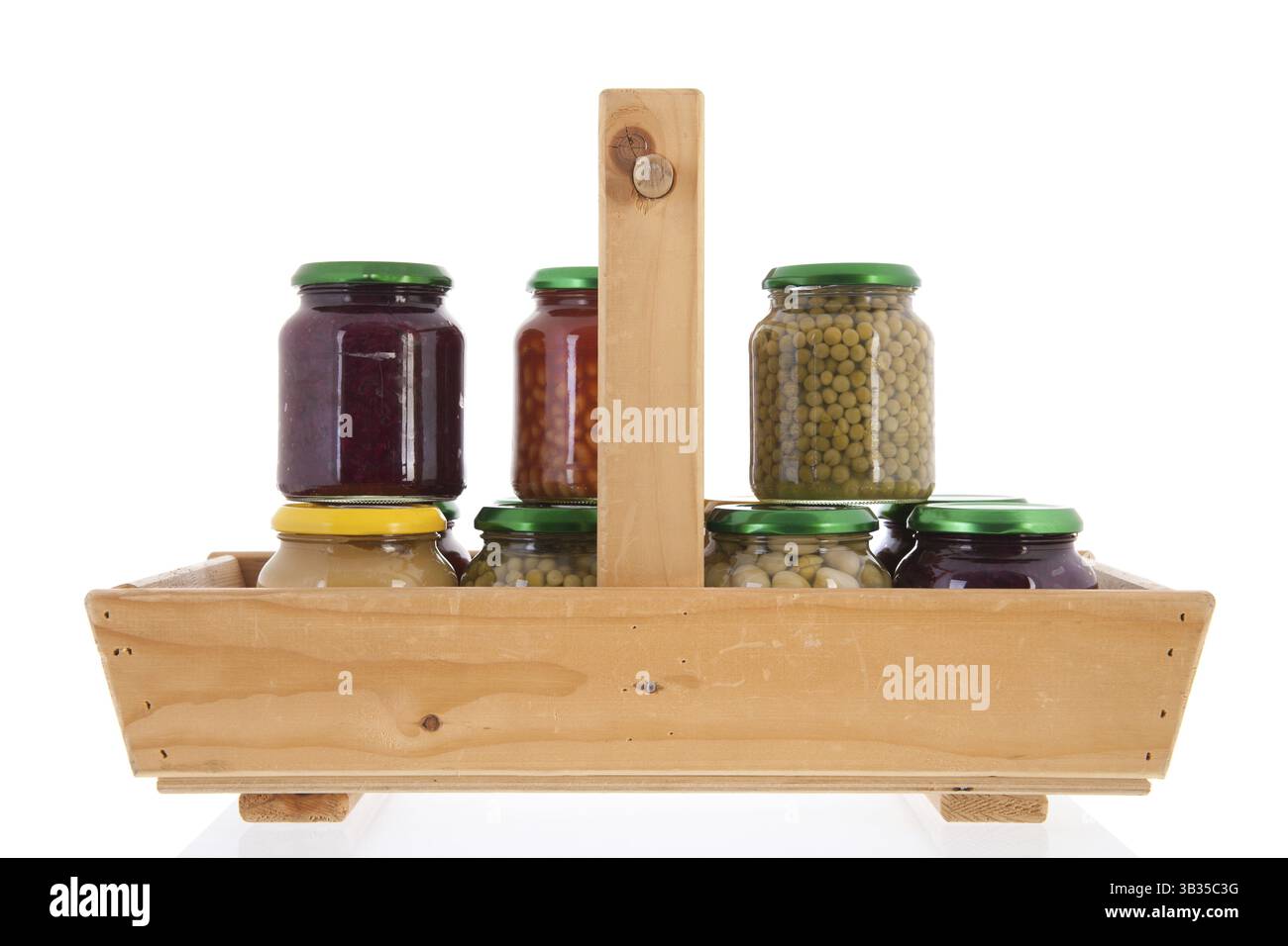 Panier en bois plein avec des pots en verre des légumes en conserve Banque D'Images