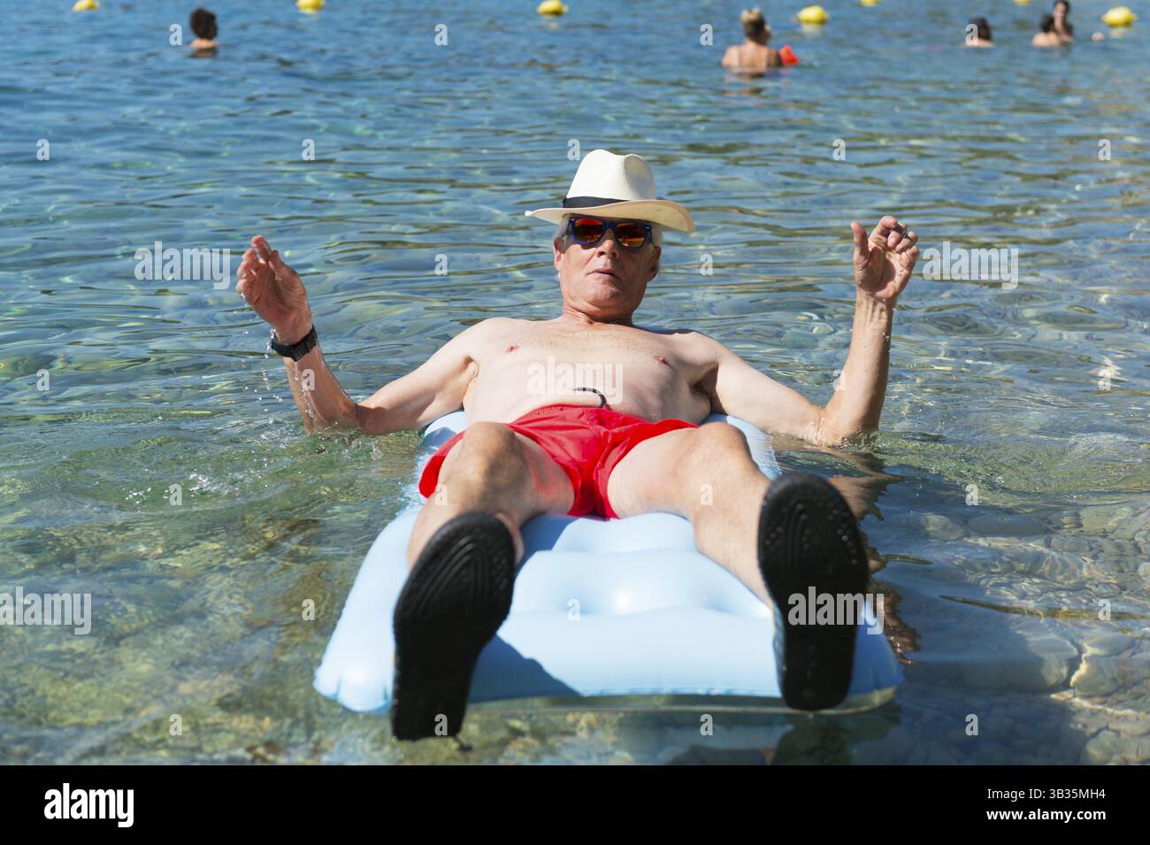 Libre de jouer avec lit gonflable flottant dans la mer Banque D'Images