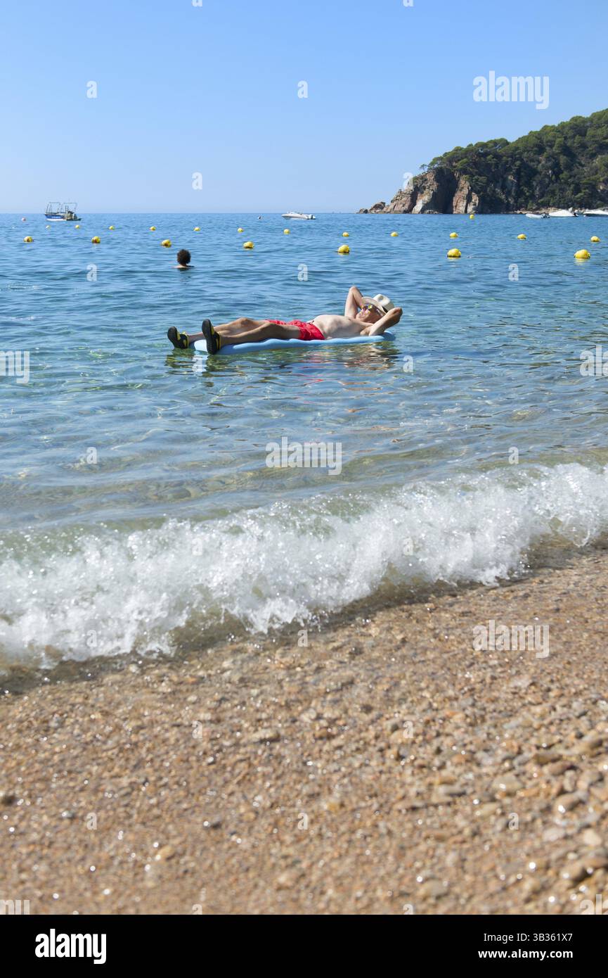 Libre de jouer avec lit gonflable flottant dans la mer Banque D'Images