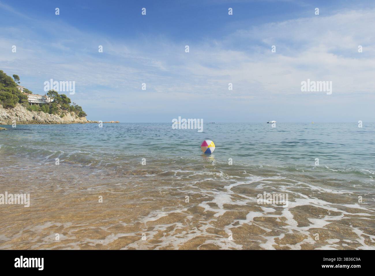 Ballon de plage gonflable coloré jouant avec le surf et la mer Banque D'Images