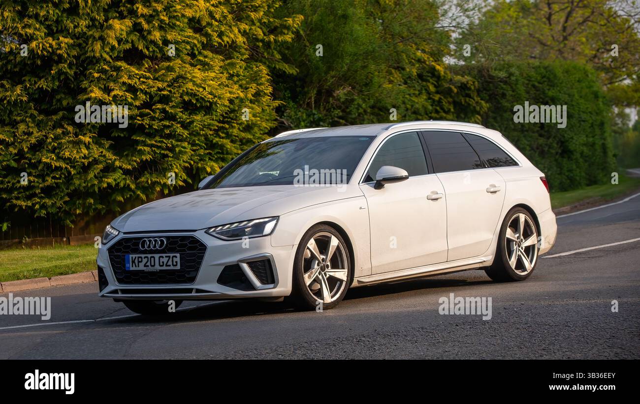 Whittlebury,Northants.,.UK - 27 avril 2025 : 2020 voiture de domaine Audi A4 blanche conduisant sur une route de campagne anglaise. Banque D'Images