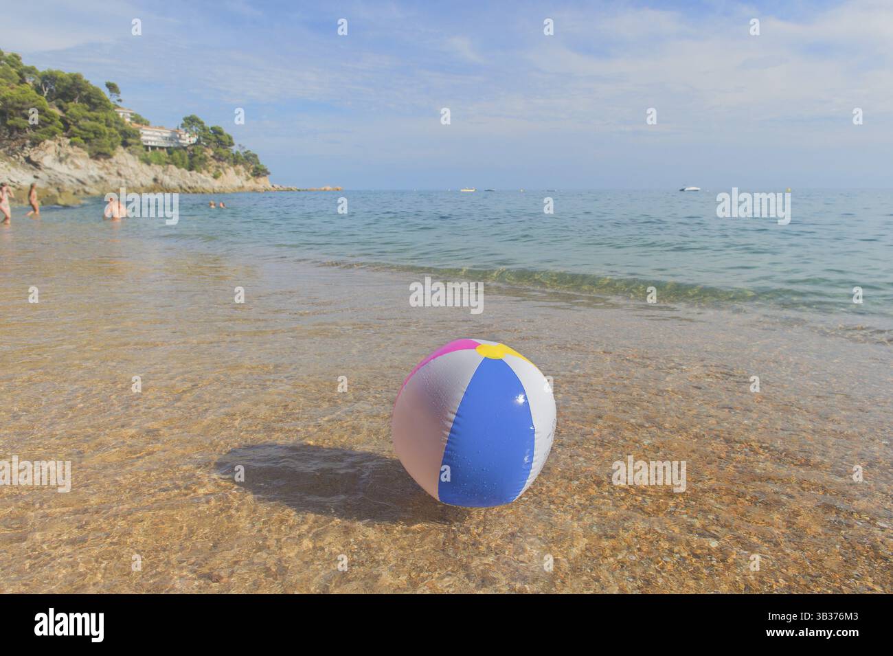 Ballon de plage gonflable coloré jouant avec le surf et la mer Banque D'Images