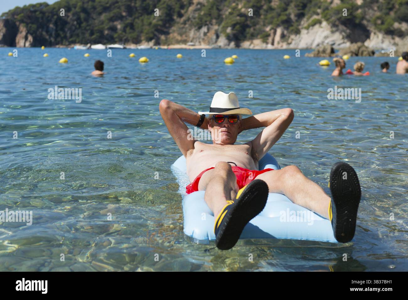 Libre de jouer avec lit gonflable flottant dans la mer Banque D'Images