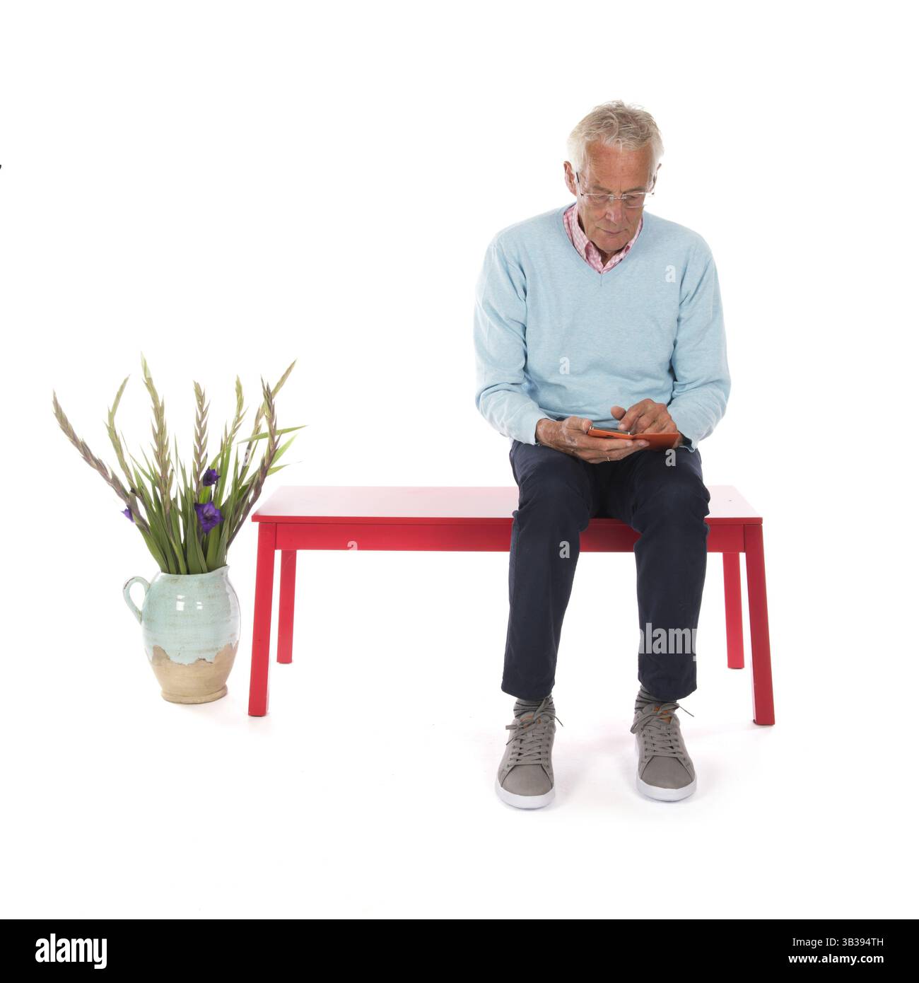 Homme âgé avec téléphone portable dans la salle d'attente Banque D'Images