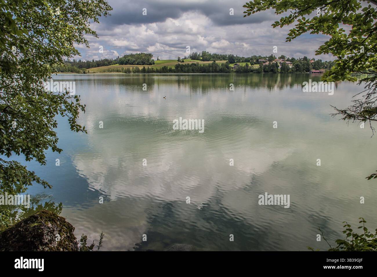 Lac Weissensee à l'ouest de Fuessen dans le district d'Ostallgaeu. Vue depuis le sentier de randonnée sur la rive sud à Oberried. Le ciel nuageux est Banque D'Images
