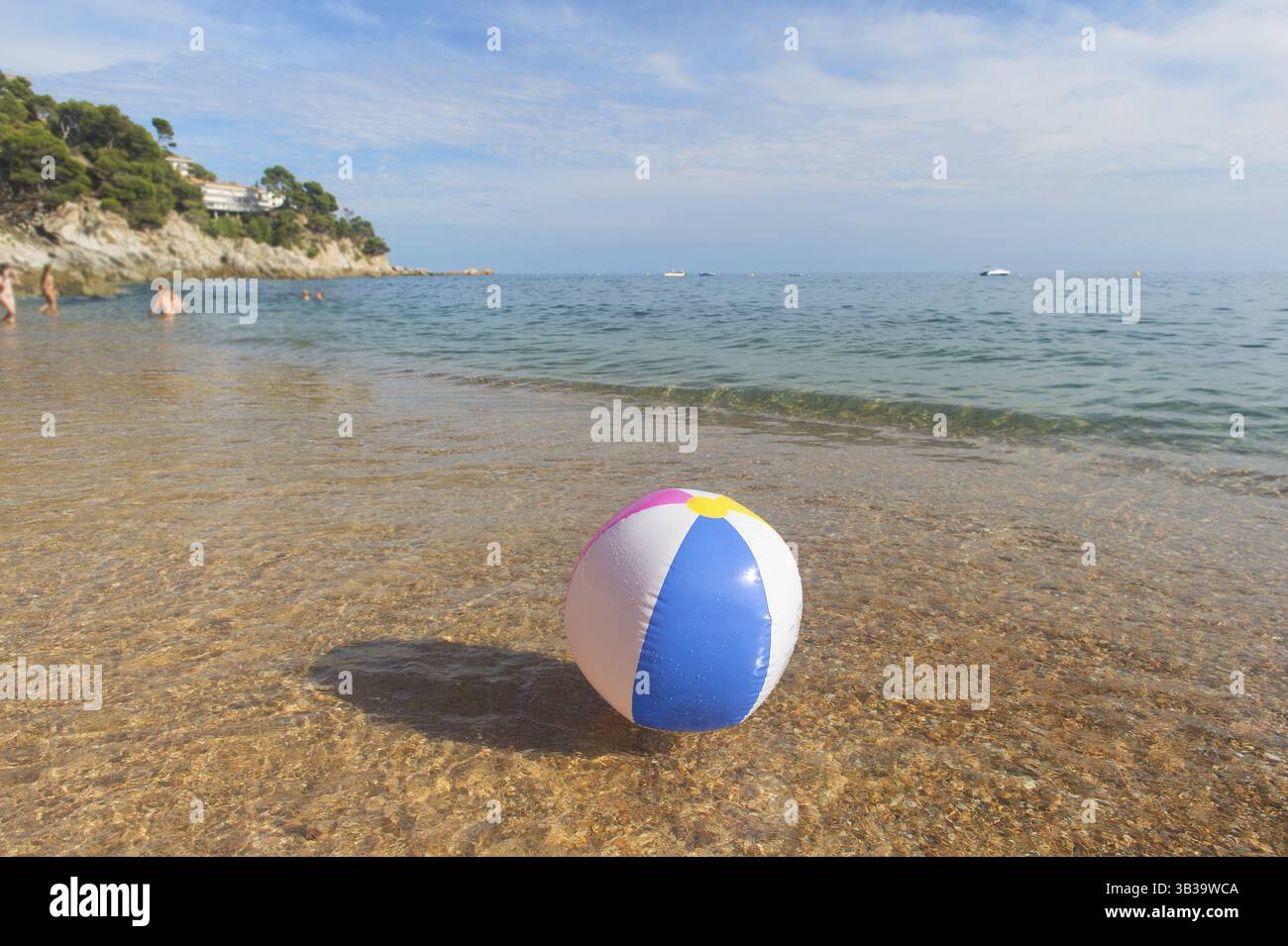 Ballon de plage gonflable coloré jouant avec le surf et la mer Banque D'Images