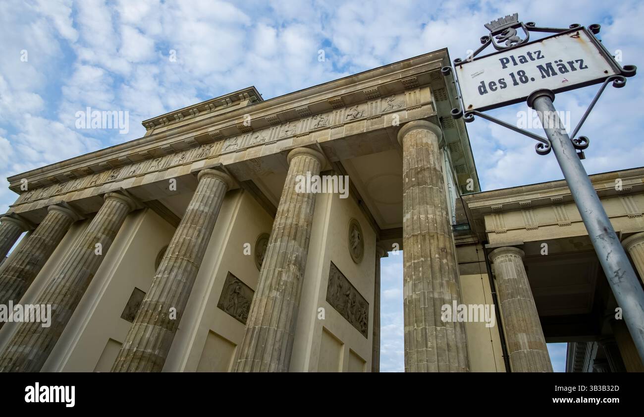Vue en bas angle de la porte de Brandebourg avec l'historique Platz des 18. Panneau de rue März à Berlin, site symbolique de la démocratie et de l'unité allemandes. Banque D'Images