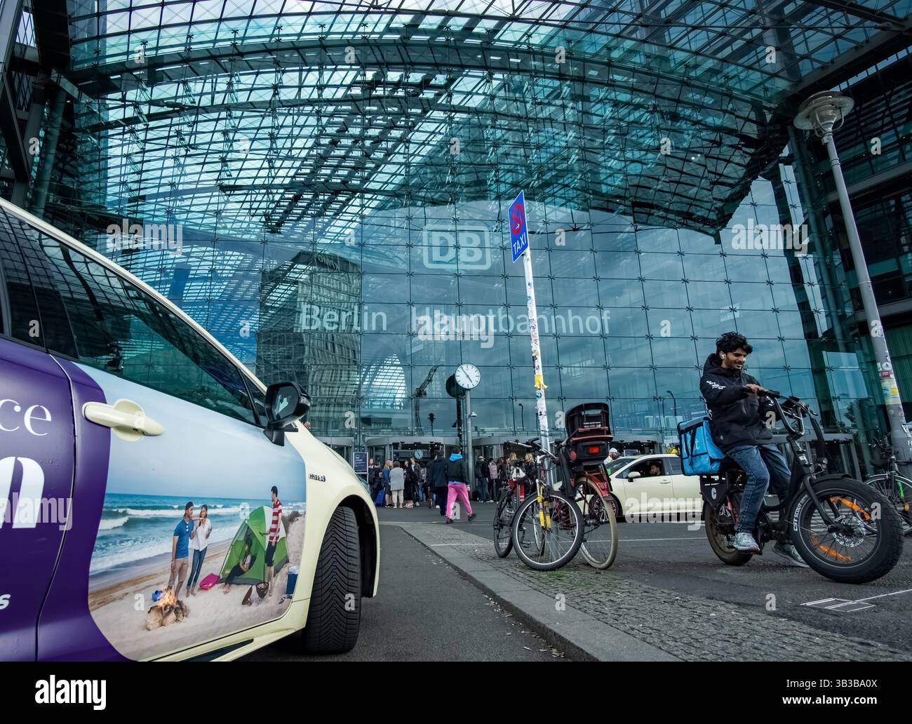 Vue sur l'entrée principale de Berlin Hauptbahnhof (gare centrale) avec façade vitrée, vélos, zone de taxis et les gens en face du bâtiment. Banque D'Images