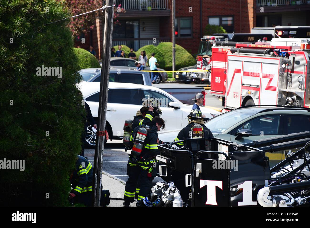 RACE : un incendie de maison menace de se propager à celui des maisons voisines alors que l'équipe d'intervention d'urgence travaille dur pour protéger la communauté du danger. Banque D'Images