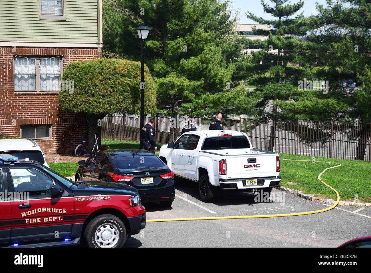RACE : un incendie de maison menace de se propager à celui des maisons voisines alors que l'équipe d'intervention d'urgence travaille dur pour protéger la communauté du danger. Banque D'Images