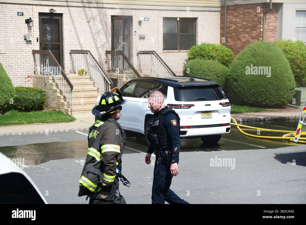 RACE : un incendie de maison menace de se propager à celui des maisons voisines alors que l'équipe d'intervention d'urgence travaille dur pour protéger la communauté du danger. Banque D'Images