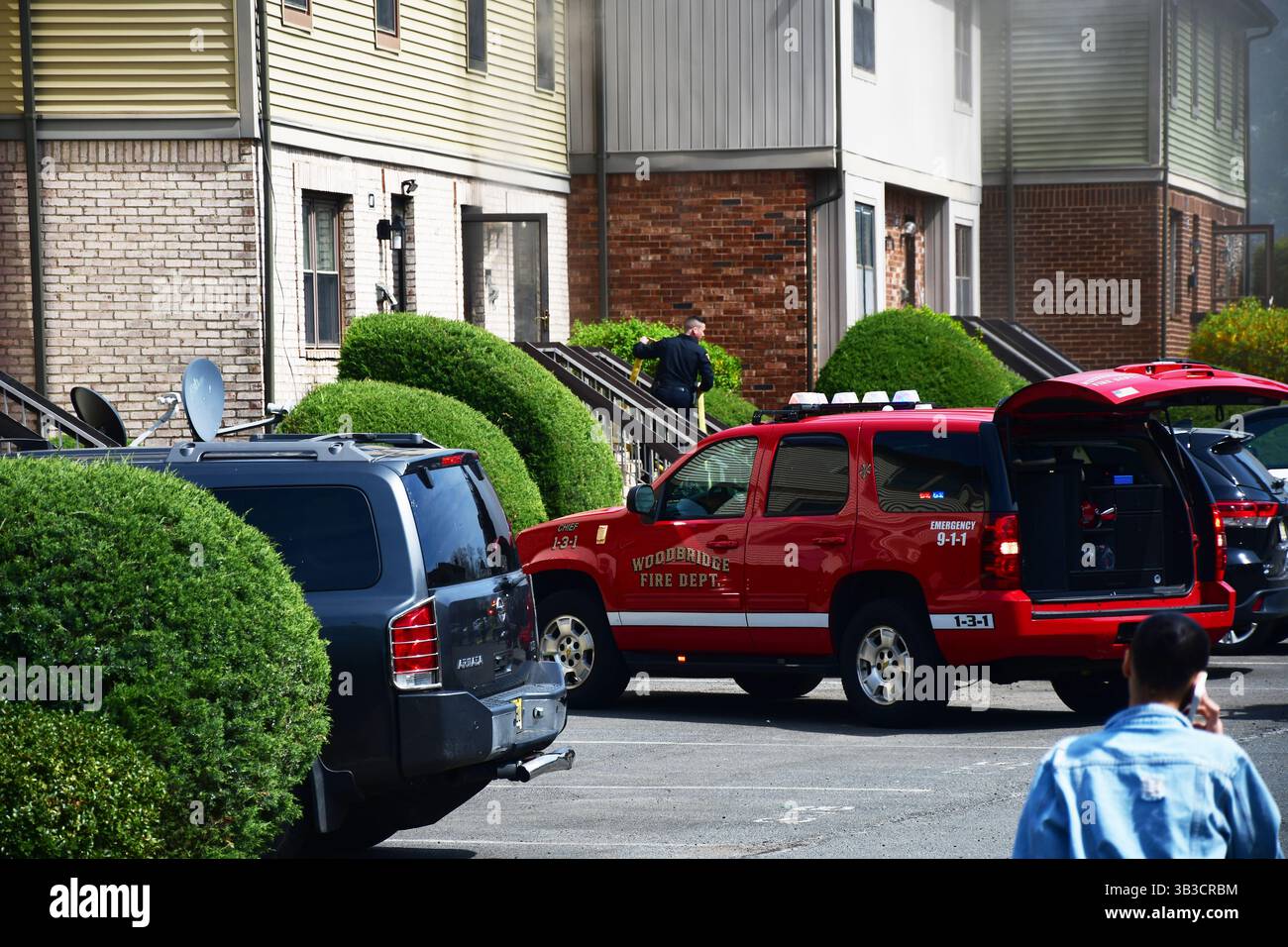 RACE : un incendie de maison menace de se propager à celui des maisons voisines alors que l'équipe d'intervention d'urgence travaille dur pour protéger la communauté du danger. Banque D'Images