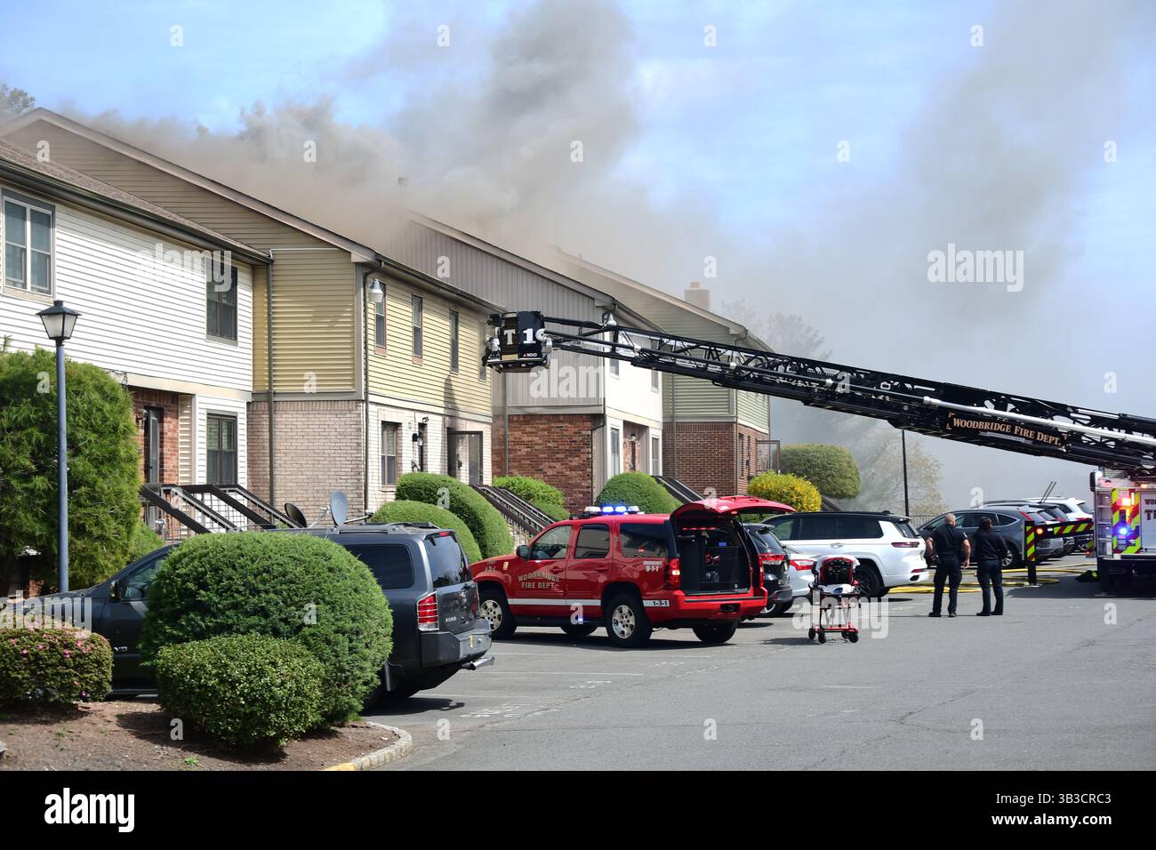 RACE : un incendie de maison menace de se propager à celui des maisons voisines alors que l'équipe d'intervention d'urgence travaille dur pour protéger la communauté du danger. Banque D'Images