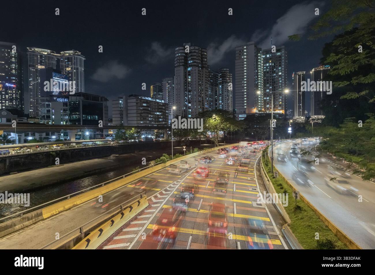Voiture se précipitant sur la route urbaine animée dans le centre-ville de Kuala Lumpur la nuit Banque D'Images