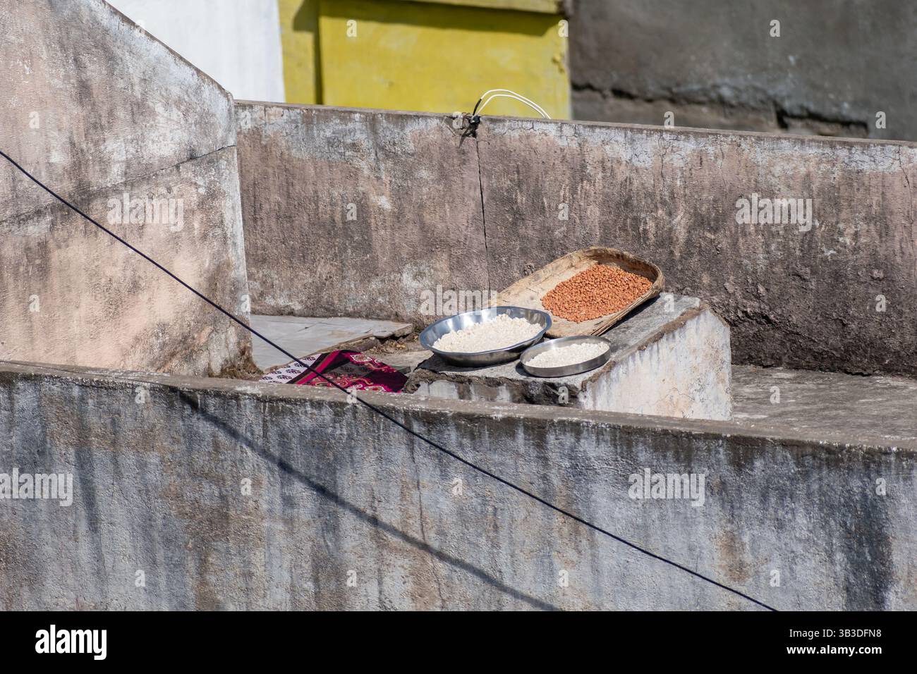 Assiettes de grains et de farine séchant sur un toit à la lumière du soleil pendant une journée claire Banque D'Images