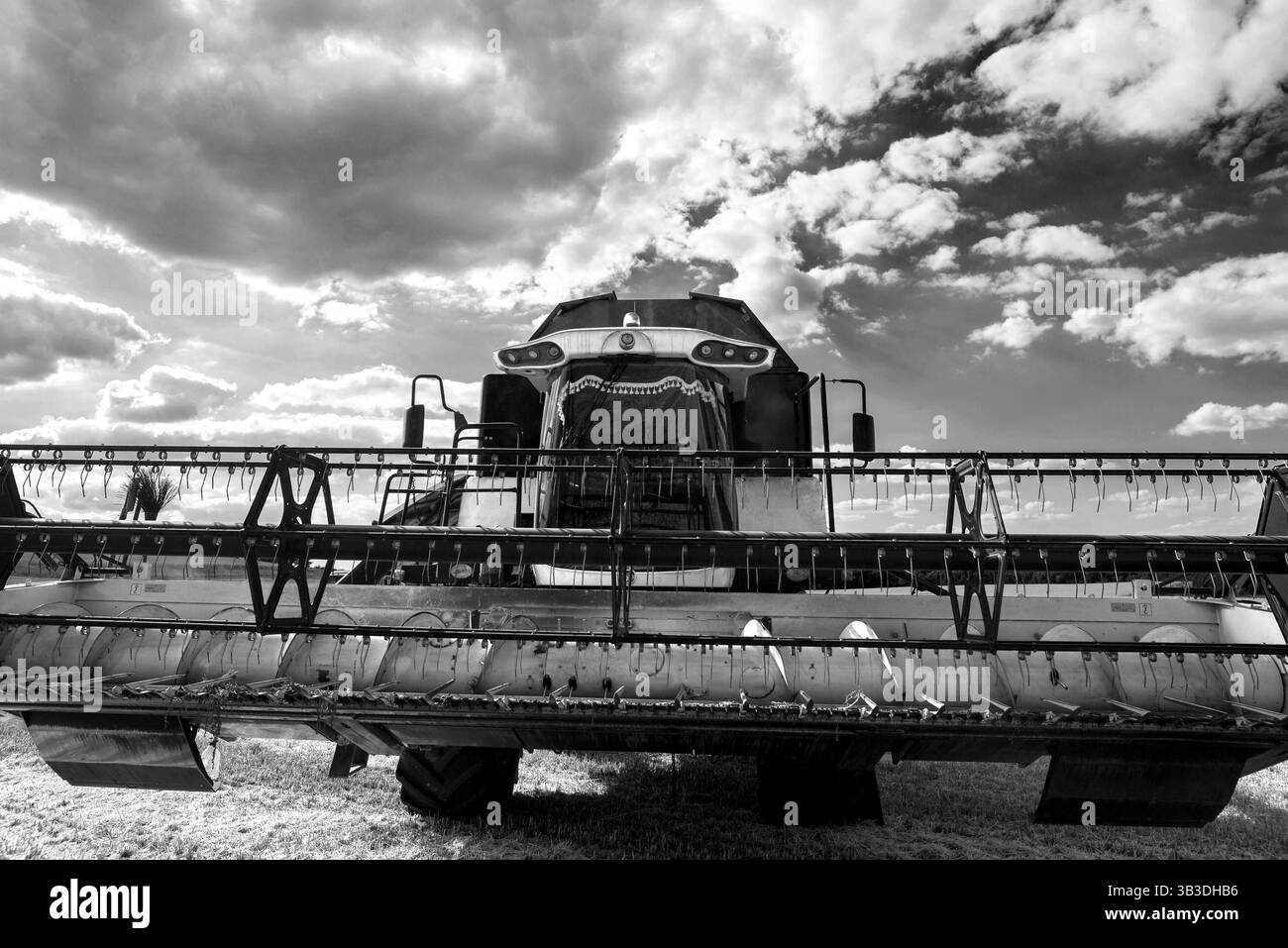 Une moissonneuse-batteuse moderne se tient sur le terrain pendant la récolte. Vue de dessous avec lentille grand angle sur la barre de coupe à tablier à châssis articulé Banque D'Images