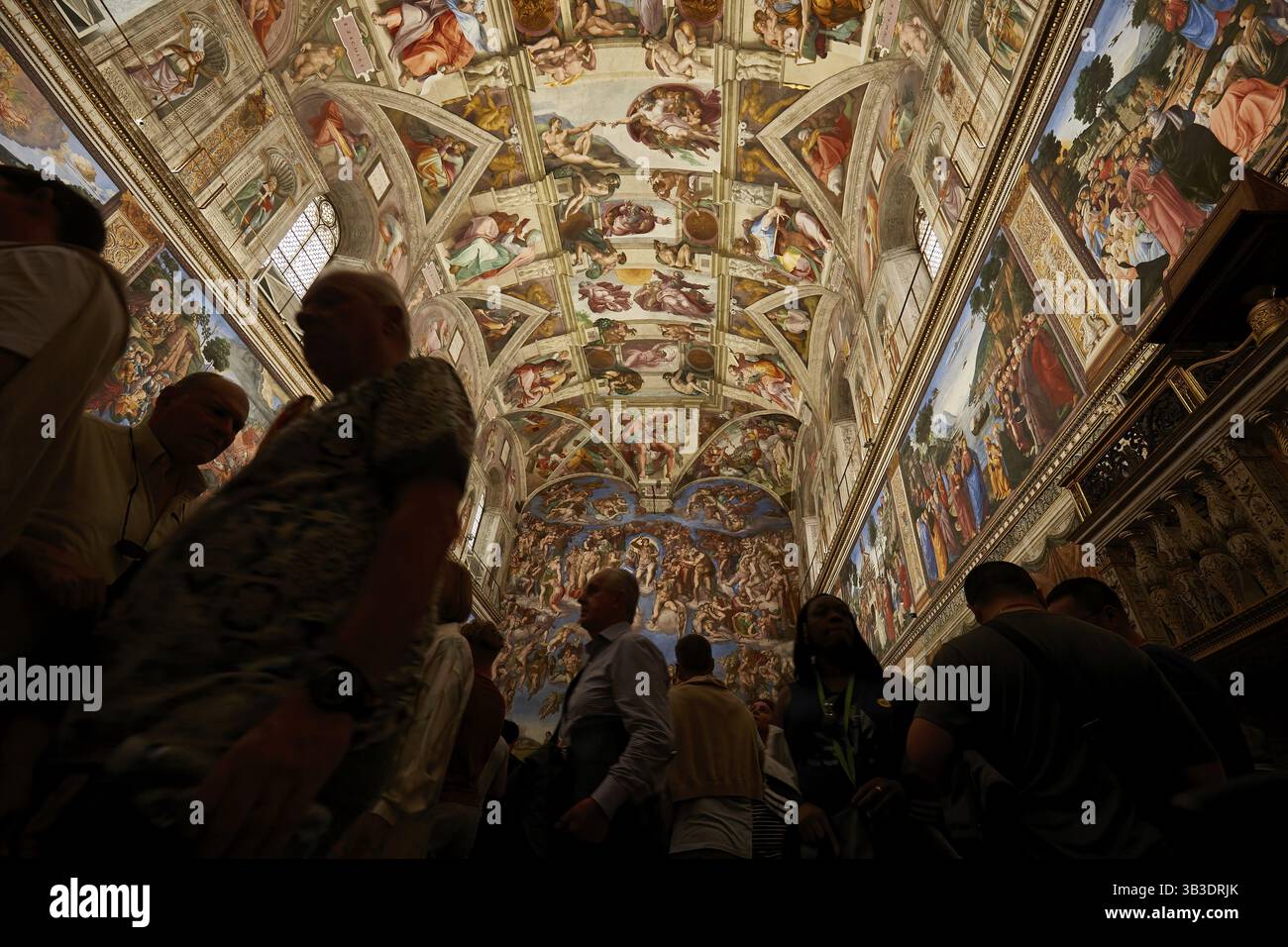 Les gens admirent le plafond richement décoré de la chapelle Sixtine avec ses célèbres fresques Renaissance Vatican Rome Italie Banque D'Images