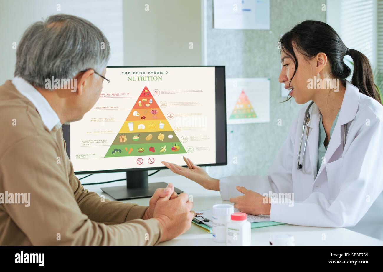 Médecin expliquant une alimentation saine et la pyramide alimentaire au patient senior pendant le conseil nutritionnel Banque D'Images