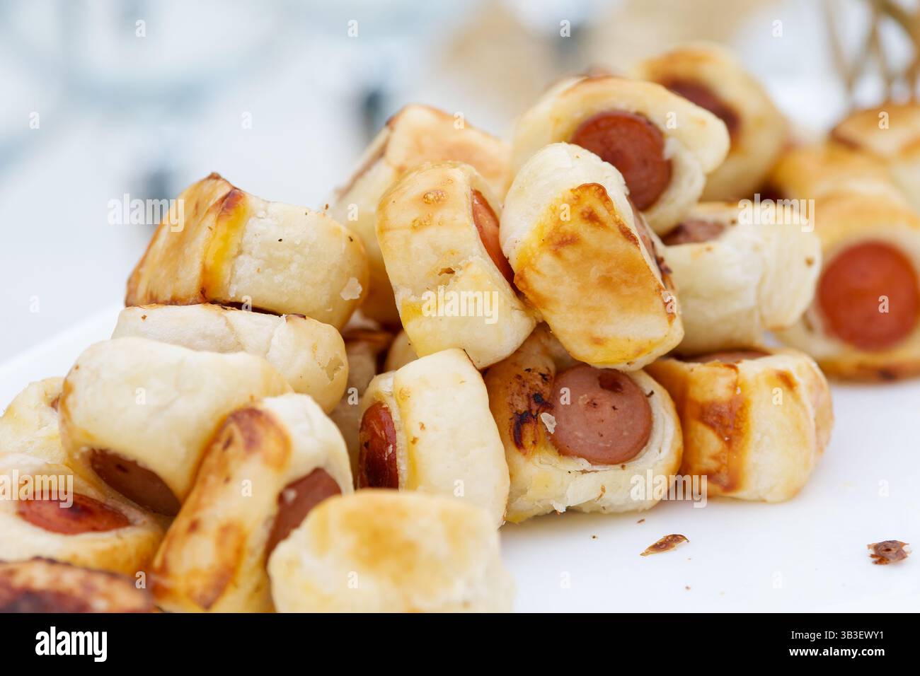 Rouleaux de saucisse dorés dans une pâte feuilletée — hors-d'œuvre croustillants et salés idéaux pour les fêtes, les buffets ou les collations décontractées. Banque D'Images