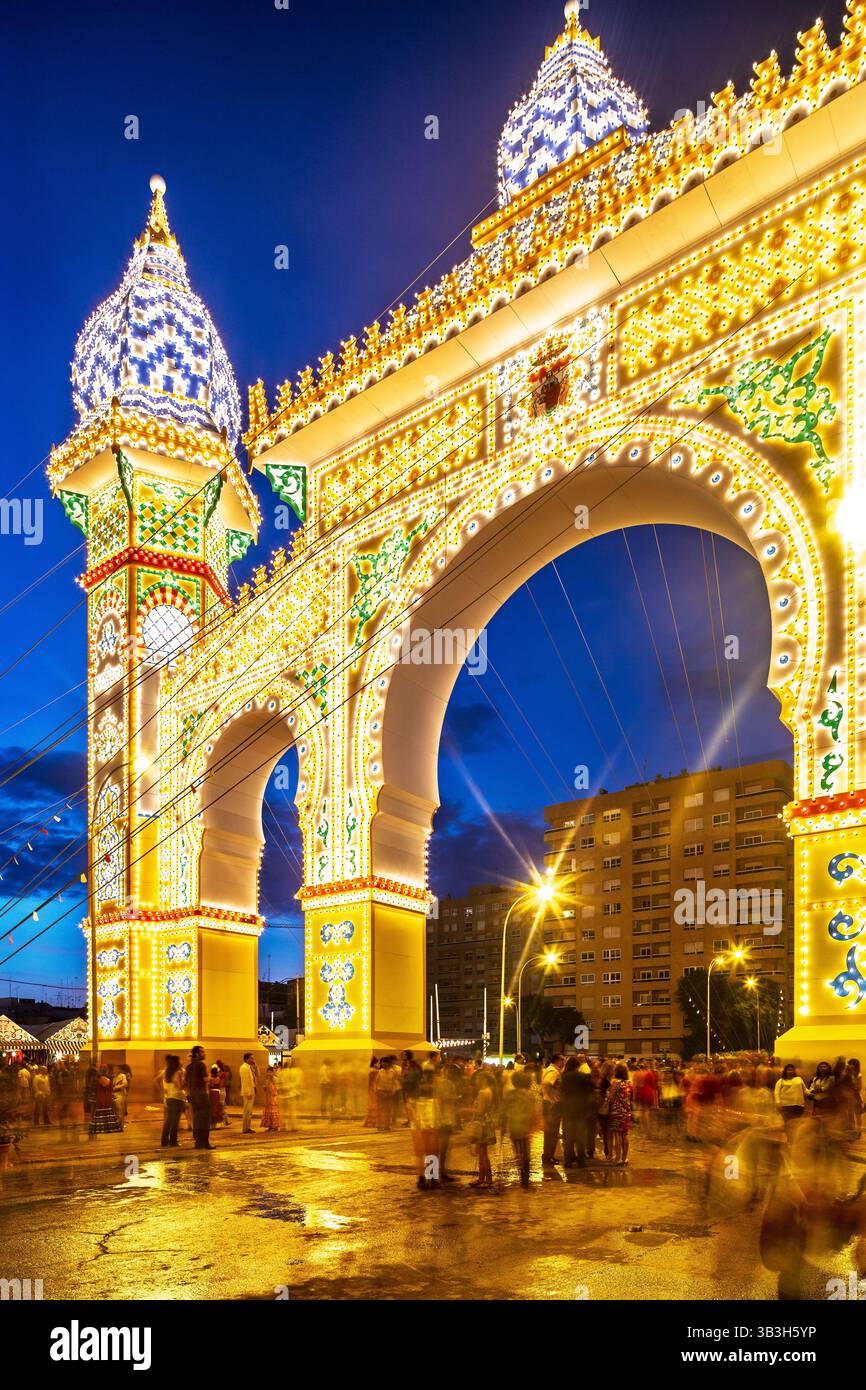 Séville, Espagne, 9 mai 2014, la porte animée de la Foire de Séville brille au crépuscule, attirant les foules pour profiter de l'atmosphère festive et AC Banque D'Images