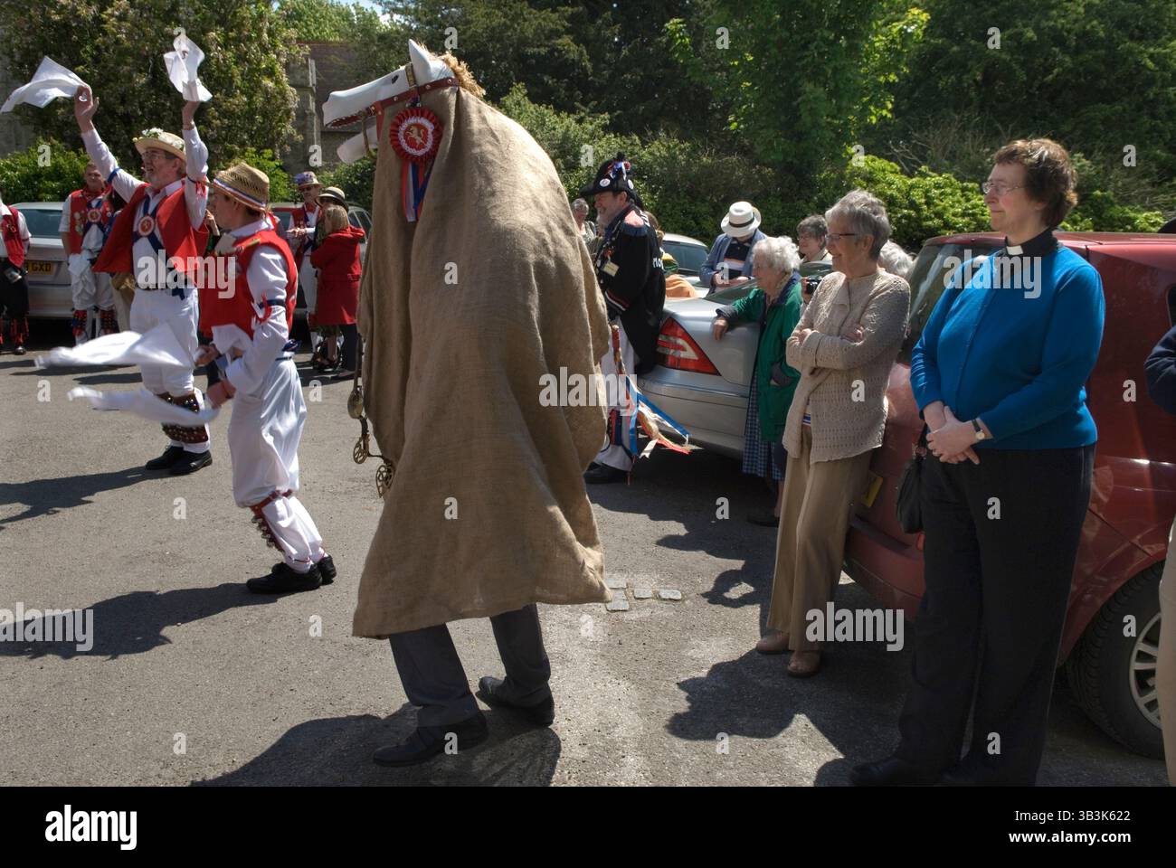 Hooden Horse East Kent Morris hommes dansant sur place devant l'église de St Peter et St Pau, l Charing, Kent. Rev Shelia Cox montres. Lundi jour férié du printemps. Angleterre des années 2013 2010 Royaume-Uni HOMER SYKES Banque D'Images