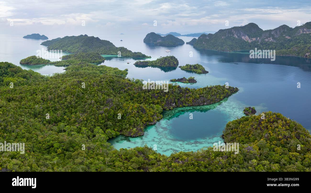 Des îles de calcaire accidentées naissent des mers chaudes de Misool, Raja Ampat. Cette région tropicale est une destination populaire pour les plongeurs et les plongeurs. Banque D'Images
