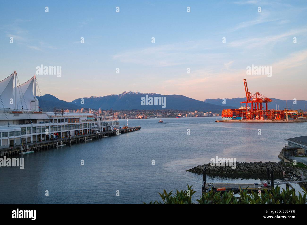 Canada place le long de Coal Harbour à Vancouver, C.-B. avec le terminal du Port de Vancouver au loin avec North Vancouver de l'autre côté de Burrard Inlet. Banque D'Images