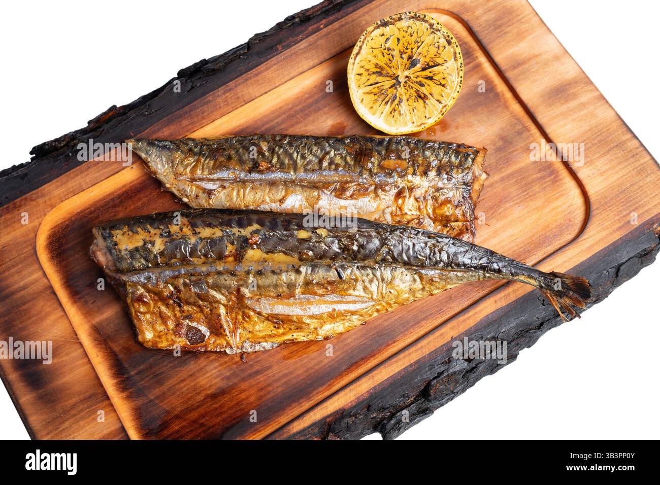 Les filets de poisson fraîchement grillés sont présentés sur une planche de bois, accompagnés d'une moitié de citron rôti. L'arôme et la présentation soulignent un se délicieux Banque D'Images