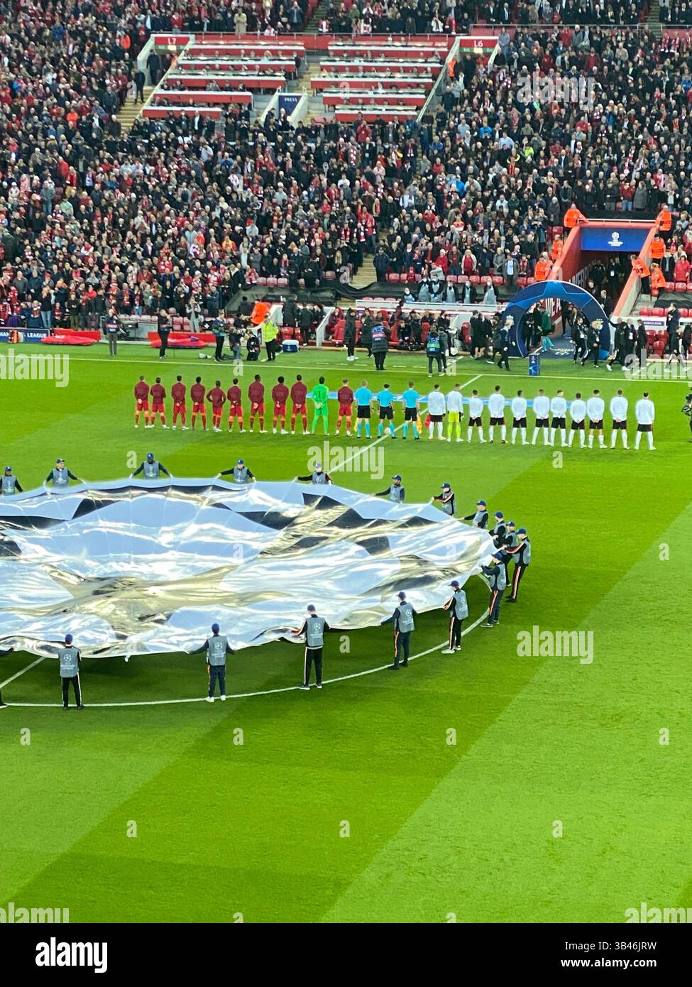 Les joueurs de Liverpool vs Benfica s'alignent à Anfield avant le match de Ligue des Champions, le 13 avril 2022, avec un affichage géant de balles de l'UEFA derrière. - Image de stock capturée avec un smartphone
