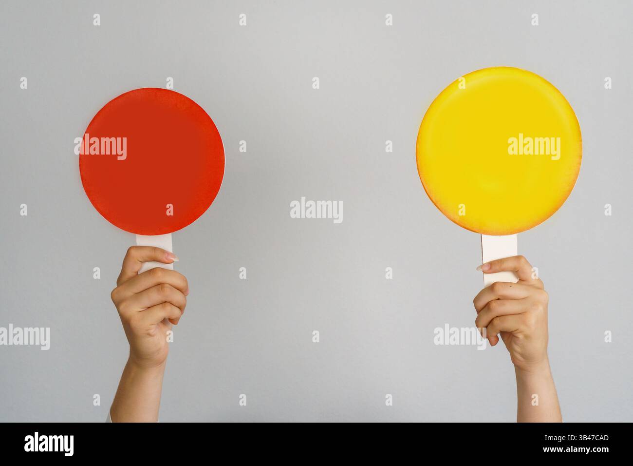 Main féminine tenant le signe de bannière de maquette vierge comme espace de copie pour le texte de citation ou la conception graphique. Signe cercle rouge et cercle jaune dans la main féminine sur Banque D'Images