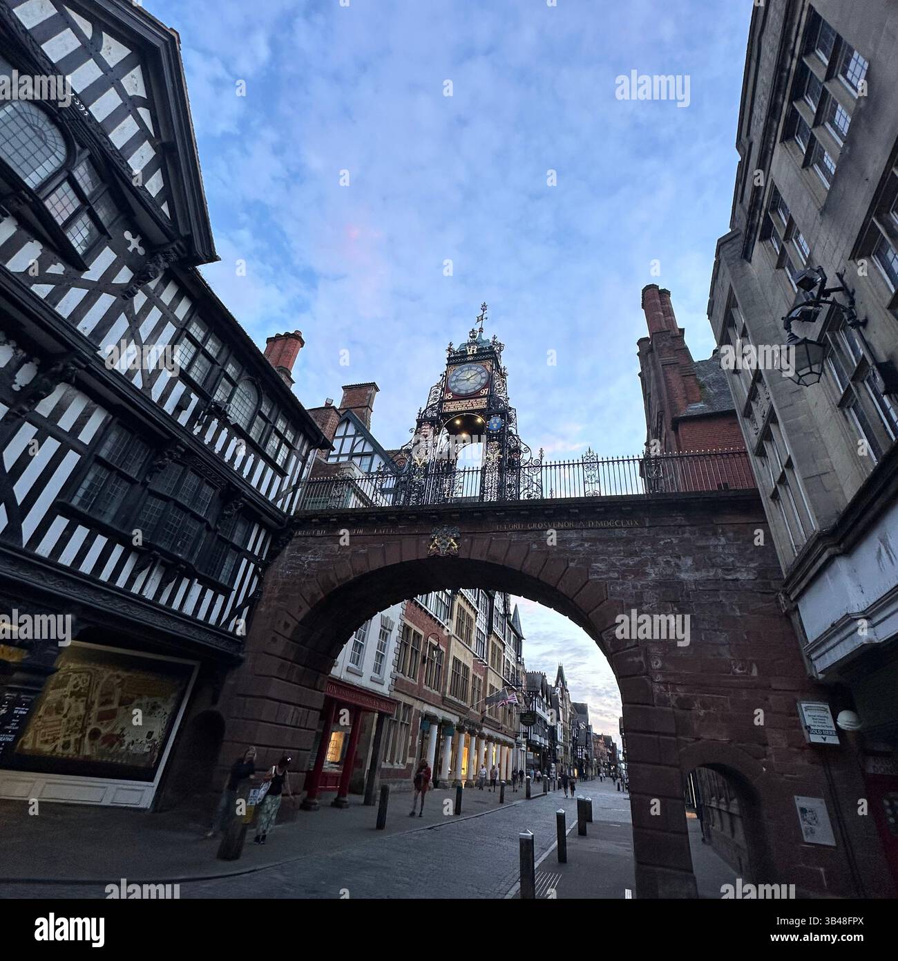 Eastgate horloge et pont vu de Eastgate Street, Chester, avec des bâtiments historiques et une circulation piétonne légère. 29 juillet 2024. - Image de stock capturée avec un smartphone