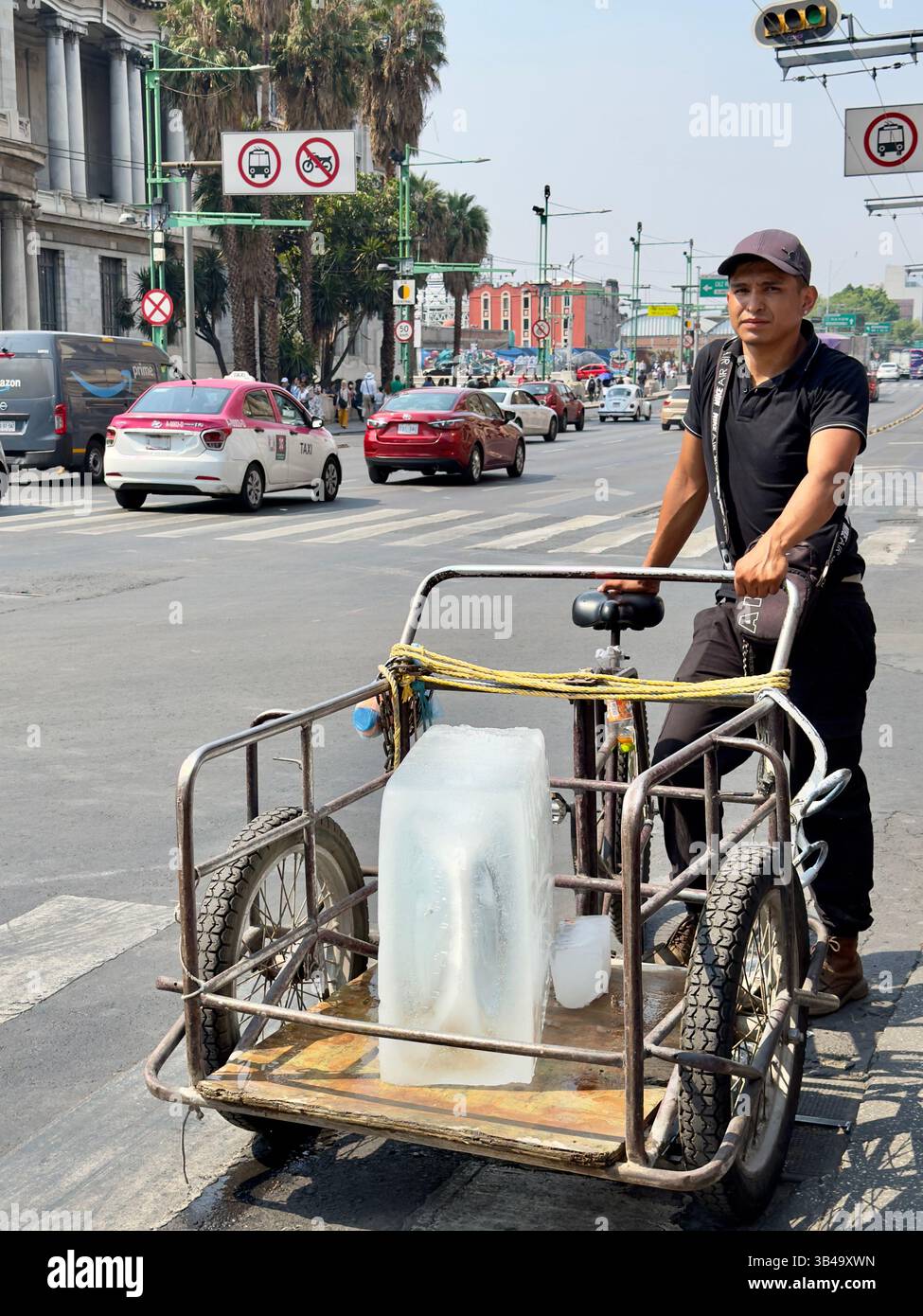 Homme transportant un énorme bloc de glace sur son tricycle, Mexico, Mexique Banque D'Images