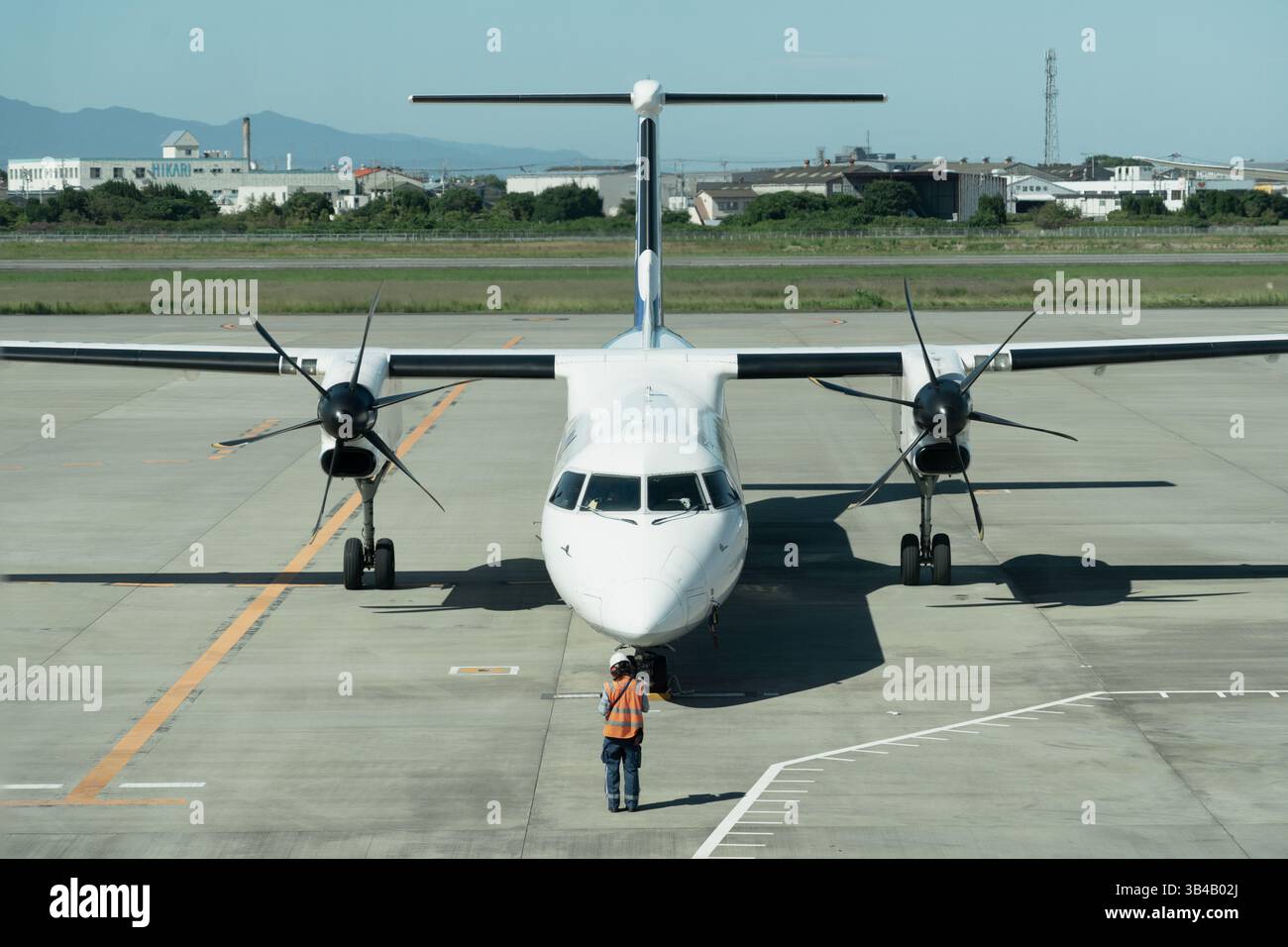 Vue de face d'un avion à turbopropulseur stationné sur la piste avec équipage au sol Banque D'Images