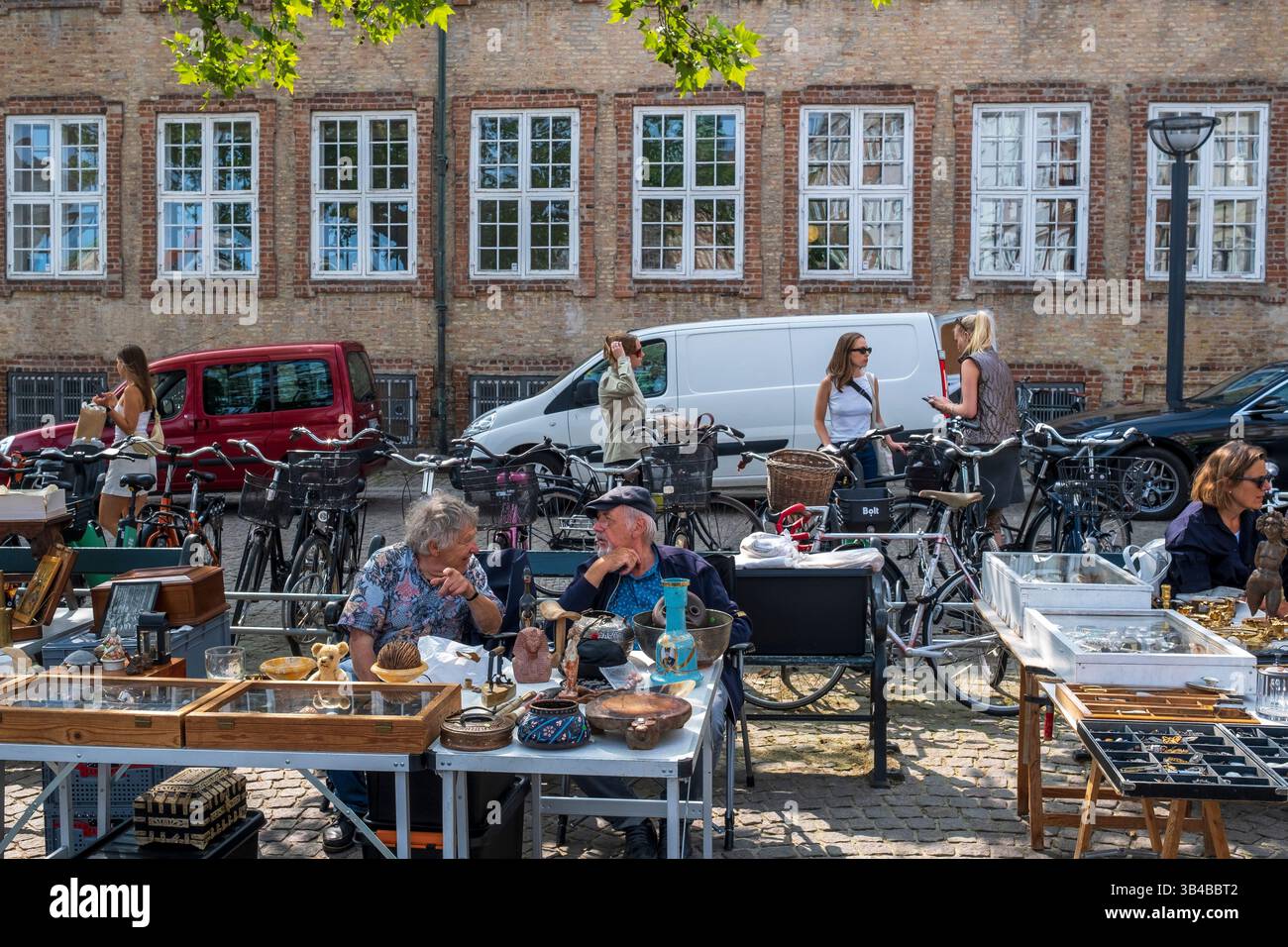 Vendeurs parlant à un marché d'antiquités en plein air dans le centre de Copenhague, Danemark Banque D'Images