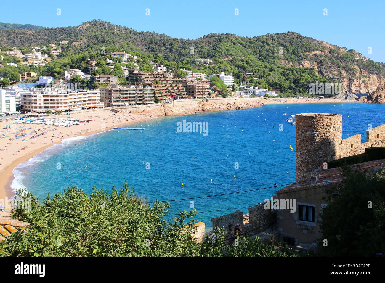 Vue aérienne des hôtels de bord de mer et des touristes d'été. Une scène estivale animée sur la plage principale de Tossa de Mar, une station balnéaire côtière sur la Costa Brava Banque D'Images