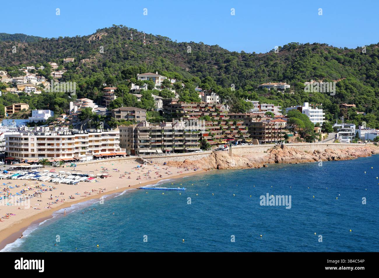 Vue aérienne des hôtels de bord de mer et des touristes d'été. Une scène estivale animée sur la plage principale de Tossa de Mar, une station balnéaire côtière sur la Costa Brava Banque D'Images