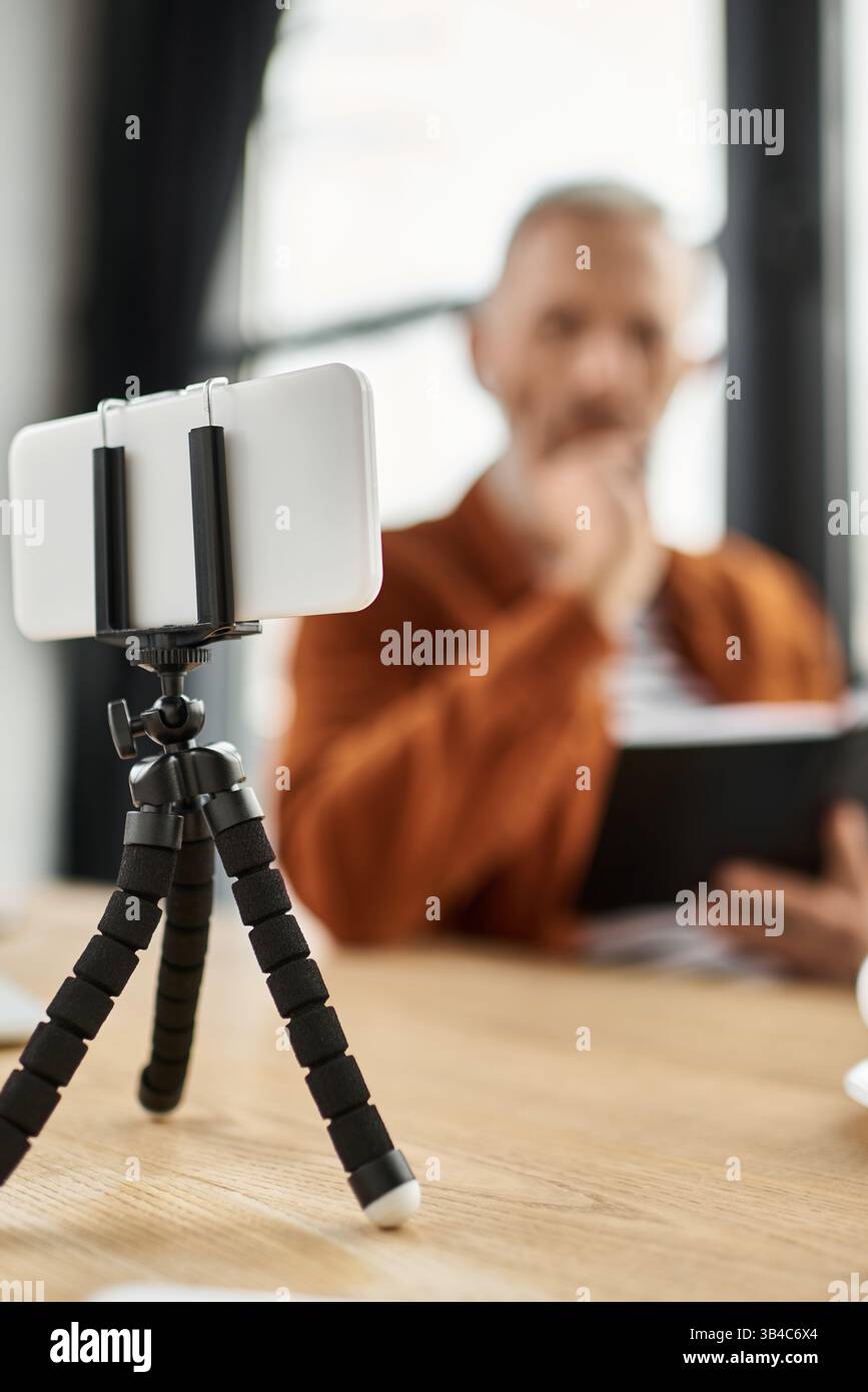 Un individu focalisé remue des idées, entouré par la technologie, dans un environnement de bureau dynamique. Banque D'Images