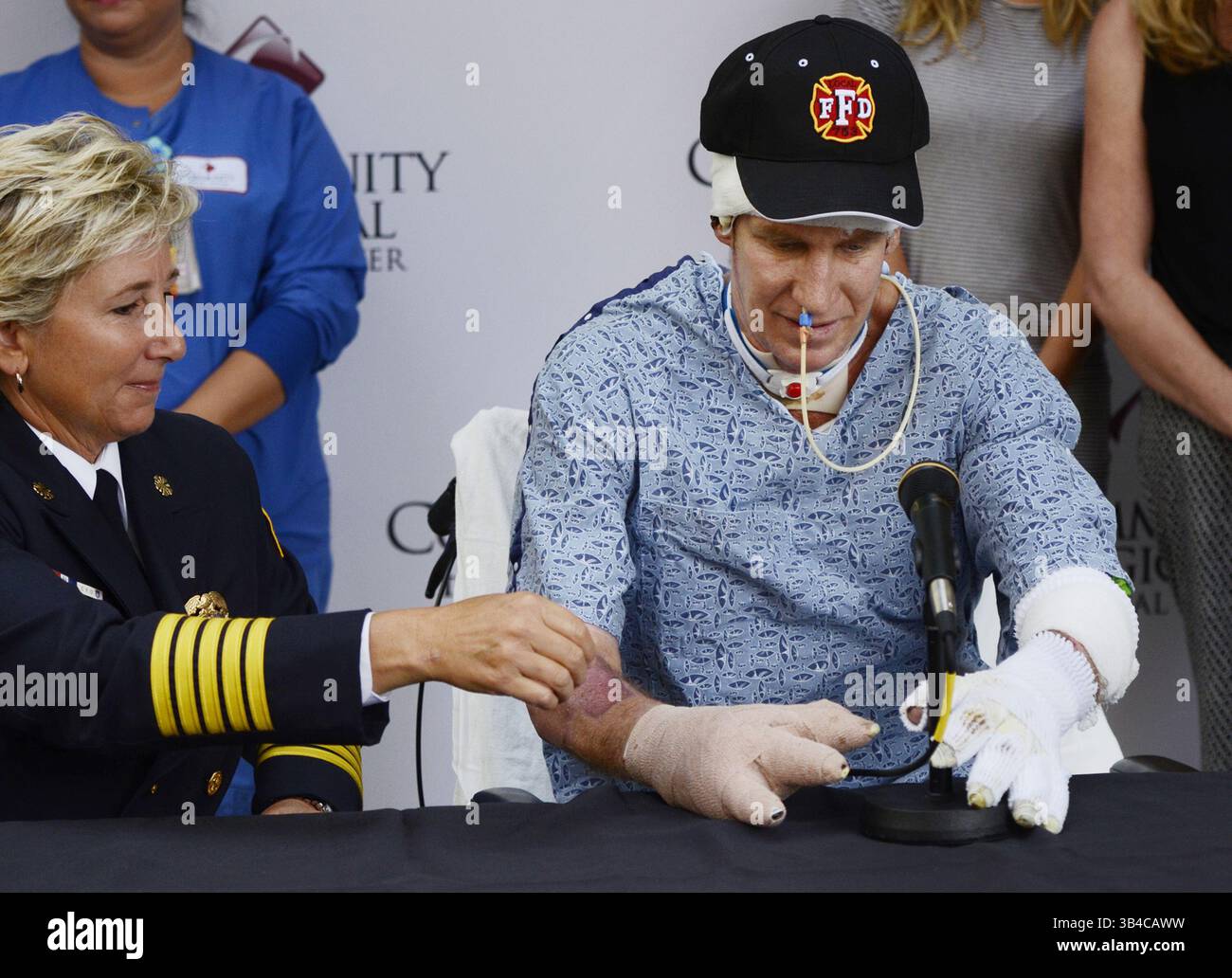 9 juillet 2015 - Fresno, CA, États-Unis - le chef des pompiers de Fresno, Kerri Donis, à l'extrême gauche, assiste le capitaine des pompiers de Fresno Pete Dern avec le micro, à droite, lors d'une conférence de presse vendredi matin, 9 juillet 2015 à Fresno, Calif. Pete Dern, qui a souffert de brûlures à 70% sur son corps après avoir pris feu dans le toit d'un garage en mars, a récupéré au Community Regional Medical Center. (Crédit image : © Eric Paul Zamora/TNS/ZUMA Wire) Banque D'Images