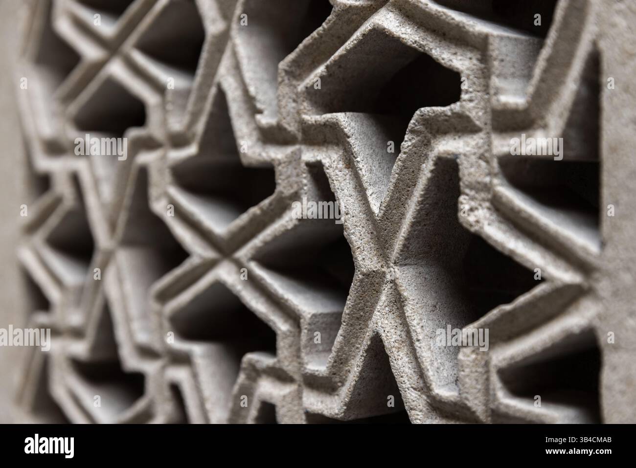 Gros plan sur le motif géométrique arabe avec des symétries interconnectées, évoquant des conceptions islamiques traditionnelles, avec des tons de grès neutres créant c Banque D'Images